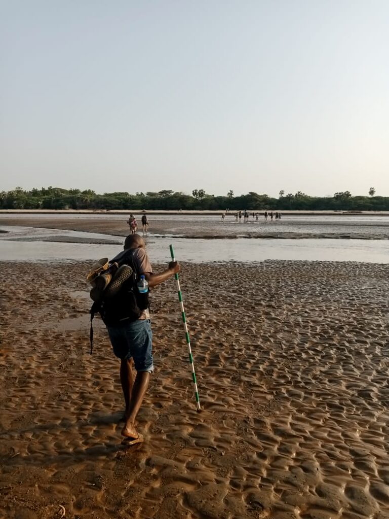 Sylvester Musyoka crossing the Turkwel River near the TBI camp for a lecture on lake deposits and how the landscape has changed over time at the Turkwel River Delta. 